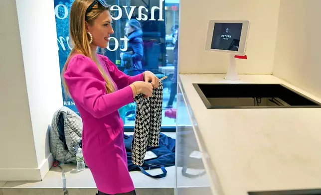 FILE - Vara Pikor returns an item at a clothing rental store in New York on Nov. 25, 2019. (AP Photo/Seth Wenig, File)