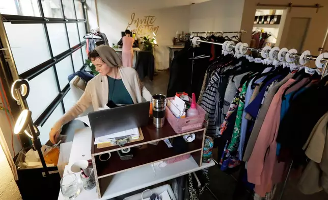 FILE - Madeline Smith packages clothing for shipments as she works for Armoire, a clothing-rental company based out of The Riveter, a women-focused shared workspace facility in Seattle, Jan. 11, 2019. (AP Photo/Ted S. Warren, File)