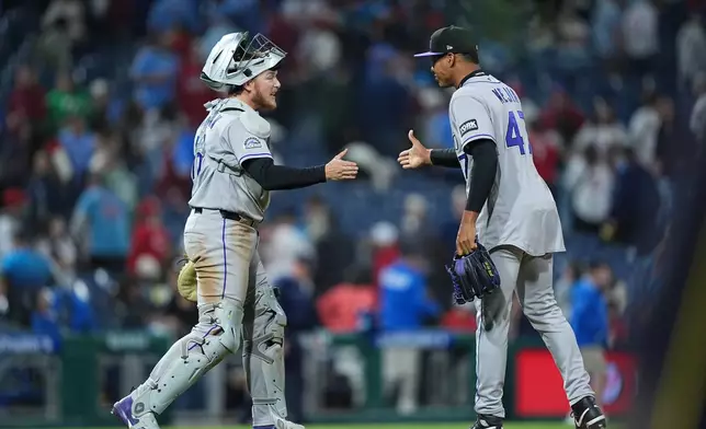 Colorado Rockies pitcher Juan Mejia and catcher Hunter Goodman celebrate after winning a baseball game against the Philadelphia Phillies, Friday, May 8, 2026, in Philadelphia. (AP Photo/Matt Rourke)