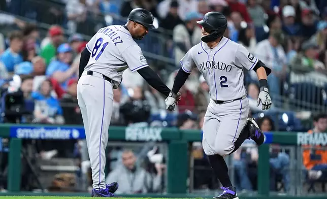 Colorado Rockies' Tyler Freeman (2) celebrates his home run off of Philadelphia Phillies pitcher Tim Mayza with Colorado Rockies third base coach Andy González during the seventh inning of a baseball game, Friday, May 8, 2026, in Philadelphia. (AP Photo/Matt Rourke)