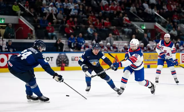 USA's Tommy Novak, right, shoots the puck past Finland's Hannes Bjorninen, left, and Waltteri Merela during the Men's Ice Hockey World Championship preliminary round game between Finland and the USA in Zurich, Switzerland, Monday, May 18, 2026. (Claudio Thoma/Keystone via AP)