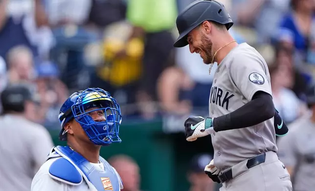 New York Yankees' Cody Bellinger runs past Kansas City Royals catcher Salvador Perez to score after hitting a solo home run during the first inning of baseball game, Tuesday, May 26, 2026, in Kansas City, Mo. (AP Photo/Charlie Riedel)