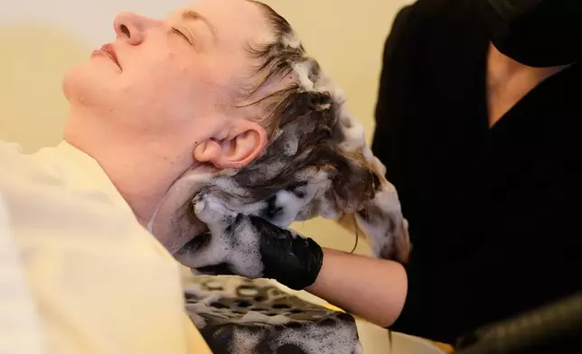 Head spa specialist Ha Truong, right, applies shampoo to Liz Evans during a treatment at Sunday Headspa Thursday, April 16, 2026, in San Francisco. (AP Photo/Jeff Chiu)