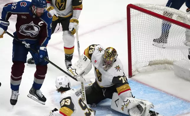 Vegas Golden Knights goaltender Carter Hart, right, stops a shot off the stick of Colorado Avalanche left wing Gabriel Landeskog during the third period in Game 1 of the Western Conference finals NHL hockey Stanley Cup playoff series Wednesday, May 20, 2026, in Denver. (AP Photo/David Zalubowski)