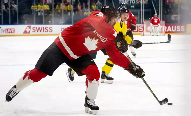 Canada's Sidney Crosby plays the puck during a Group B preliminary round game between Canada and Sweden at the men's ice hockey world championship in Fribourg, Switzerland, Friday, May 15, 2026. (Anthony Anex/Keystone via AP)