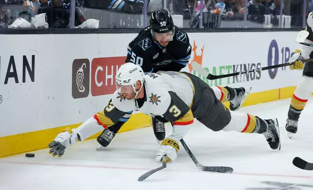 Vegas Golden Knights defenseman Brayden McNabb (3) goes down after the puck against Utah Mammoth defenseman Sean Durzi (50) during the third period of Game 6 in the first round of an NHL hockey Stanley Cup playoff series, Friday, May 1, 2026, in Salt Lake City. (AP Photo/Melissa Majchrzak)