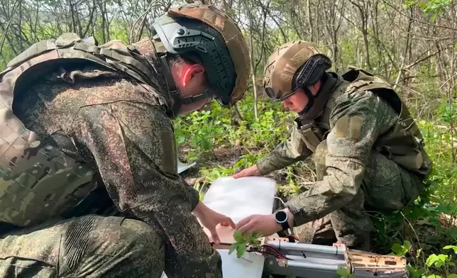 In this image made from video provided by Russian Defense Ministry Press Service on Wednesday, May 20, 2026, Russian servicemen prepare to launch an interceptor drone for an action in an undisclosed location in Ukraine. (Russian Defense Ministry Press Service via AP)