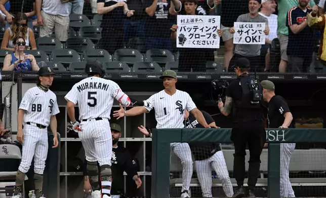 Chicago White Sox's Munetaka Murakami (5) celebrates with manager Will Venable (1) at the dugout after hitting a solo home run during the third inning of a baseball game against the Chicago Cubs in Chicago, Saturday, May 16, 2026. (AP Photo/Paul Beaty)