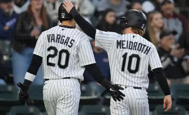 Chicago White Sox's Miguel Vargas (20), left, and Chase Meidroth (10) celebrate after scoring on a single from Randal Grichuk (34) during the third inning of a baseball game against the Kansas City Royals, Thursday, May 14, 2026, in Chicago. (AP Photo/Erin Hooley)