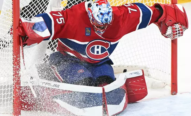 Montreal Canadiens goaltender Jakub Dobes smothers the puck just outside the net following a shot by Carolina Hurricanes' Sebastian Aho during the third period of Game 3 of the Eastern Conference finals NHL hockey Stanley Cup playoff series in Montreal, Monday, May 25, 2026. (Graham Hughes/The Canadian Press via AP)