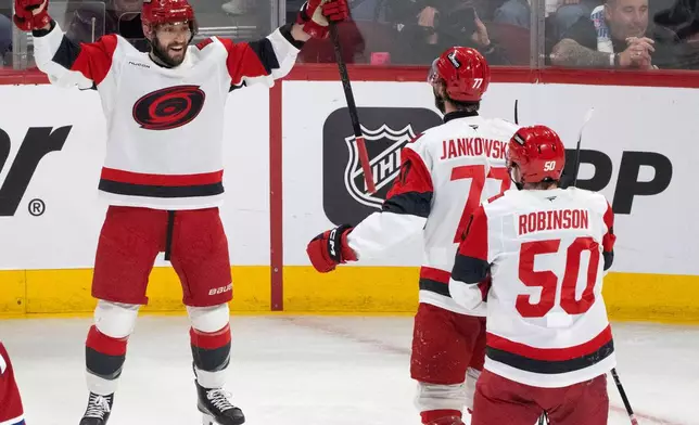 Carolina Hurricanes defenseman Shayne Gostisbehere (4) celebrates after his goal with teammates Mark Jankowski (77) and Eric Robinson (50) during the first period of Game 3 of the Eastern Conference finals NHL hockey Stanley Cup playoff series against the Montreal Canadiens in Montreal, Monday, May 25, 2026. (Christinne Muschi/The Canadian Press via AP)