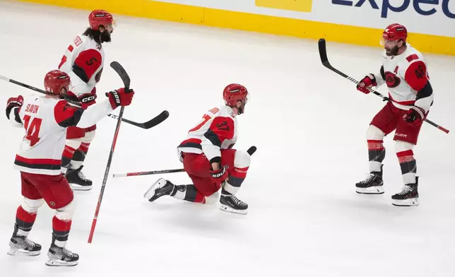 Carolina Hurricanes' Andrei Svechnikov (37) celebrates with teammates Jaccob Slavin (74), Jalen Chatfield (5) and Jordan Martinook (48) after a goal by teammate Sebastian Aho (not shown) during overtime of Game 3 of the Eastern Conference finals NHL hockey Stanley Cup playoff series against the Montreal Canadiens in Montreal, Monday, May 25, 2026. (Christinne Muschi/The Canadian Press via AP)