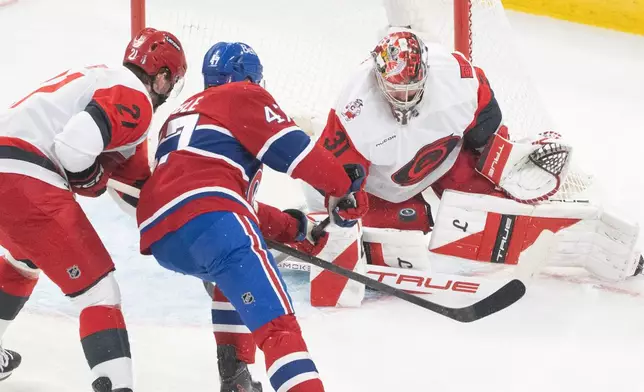 Carolina Hurricanes goaltender Frederik Andersen (31) stops Montreal Canadiens' Jayden Struble (47) as Hurricanes' Alexander Nikishin (21) defends during the second period of Game 3 of the Eastern Conference finals NHL hockey Stanley Cup playoff series in Montreal, Monday, May 25, 2026. (Christinne Muschi/The Canadian Press via AP)