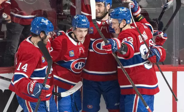 Montreal Canadiens' Lane Hutson (48) celebrates after his goal with teammates Nick Suzuki (14), Juraj Slafkovsky (20) and Ivan Demidov (93) during the second period of Game 3 of the Eastern Conference finals NHL hockey Stanley Cup playoff series against the Carolina Hurricanes in Montreal, Monday, May 25, 2026. (Christinne Muschi/The Canadian Press via AP)