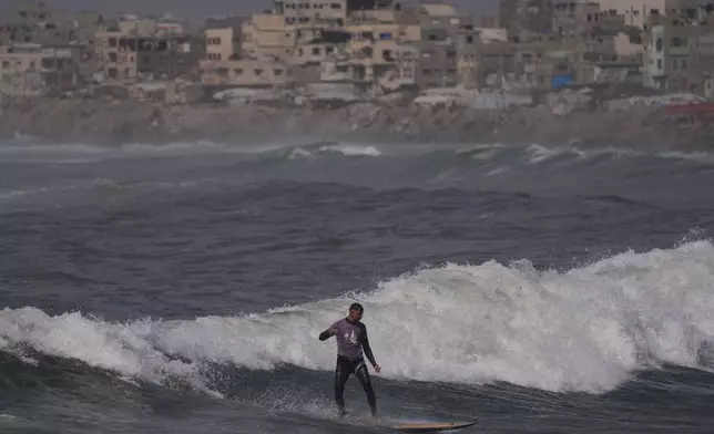 Palestinian Tahseen Abu Assi rides a wave at a beach along the Mediterranean Sea in Gaza City, Monday, May 4, 2026. (AP Photo/Jehad Alshrafi)