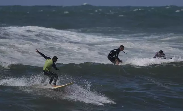 Palestinian Khalil Abu Jayyab rides a wave at a beach along the Mediterranean Sea in Gaza City, Monday, May 4, 2026. (AP Photo/Jehad Alshrafi)