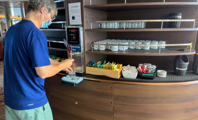 A passenger on the hantavirus-stricken cruise ship, MV Hondius, helps himself to water at the ship's self-service area during the voyage to Spain's port of Tenerife, May 6, 2026. (AP Photo)