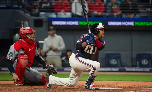 Cleveland Guardians' Jose Ramirez watches his single off Minnesota Twins starting pitcher Joe Ryan as Victor Caratini looks on during the fourth inning of a baseball game, Saturday, May 9, 2026, in Cleveland. (AP Photo/Phil Long)