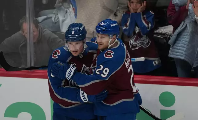 Colorado Avalanche defenseman Cale Makar, left, congratulates center Nathan MacKinnon after he scored a goal against the Minnesota Wild in the third period of Game 1 of an NHL hockey Stanley Cup second-round playoff series Sunday, May 3, 2026, in Denver. (AP Photo/David Zalubowski)