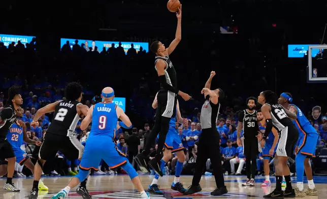 San Antonio Spurs forward Victor Wembanyama (1) tips off during overtime of Game 1 in a third-round NBA basketball playoffs series against the Oklahoma City Thunder Monday, May 18, 2026, in Oklahoma City. (AP Photo/Tony Gutierrez)