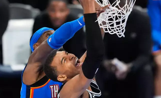 Oklahoma City Thunder guard Shai Gilgeous-Alexander, left, fouls San Antonio Spurs forward Victor Wembanyama (1) during the second half of Game 1 in a third-round NBA basketball playoffs series Monday, May 18, 2026, in Oklahoma City. (AP Photo/Tony Gutierrez)
