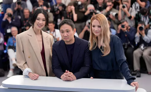 Tao Okamoto, from left, director Ryusuke Hamaguchi and Virginie Efira pose for photographers at the photo call for the film 'All of a Sudden' during the 79th international film festival, Cannes, southern France, Saturday, May 16, 2026. (AP Photo/John Locher)