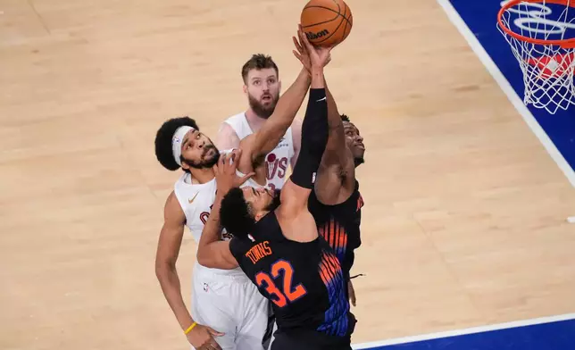New York Knicks forward Og Anunoby (8) and center Karl-Anthony Towns (32) fight for control of the ball with Cleveland Cavaliers center Jarrett Allen (31) and forward Dean Wade (32) during the second half of Game 2 in the Eastern Conference finals NBA basketball playoffs series, Thursday, May 21, 2026, in New York. (AP Photo/Yuki Iwamura)