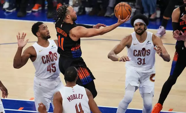 New York Knicks' Jalen Brunson (11) drives past Cleveland Cavaliers' Donovan Mitchell (45), Evan Mobley (4) and Jarrett Allen (31) during the second half of Game 2 in the Eastern Conference finals NBA basketball playoffs series, Thursday, May 21, 2026, in New York. (AP Photo/Frank Franklin II)
