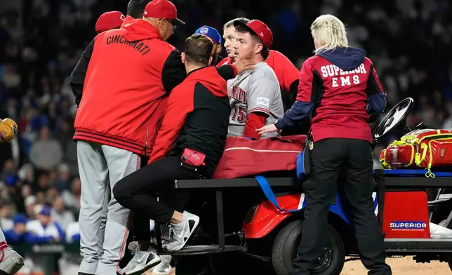 Cincinnati Reds manager Terry Francona, left, talks to relief pitcher Emilio Pagán, as he leaves the field after an injury during the ninth inning of a baseball game against the Chicago Cubs in Chicago, Tuesday, May 5, 2026. (AP Photo/Nam Y. Huh)