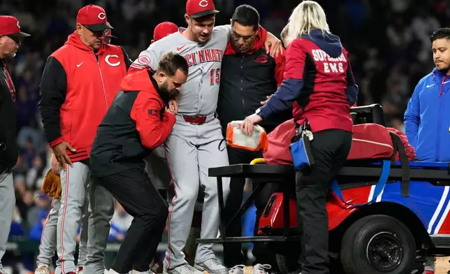 Cincinnati Reds relief pitcher Emilio Pagán (15) is helped by team trainers after an injury during the ninth inning of a baseball game against the Chicago Cubs in Chicago, Tuesday, May 5, 2026. (AP Photo/Nam Y. Huh)