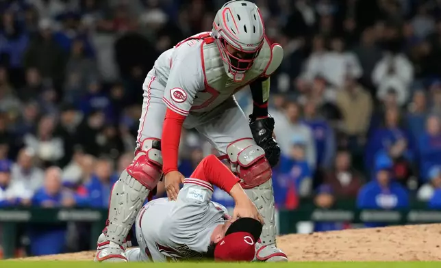 Cincinnati Reds relief pitcher Emilio Pagán lies on the field as he is checked by catcher Tyler Stephenson after an injury during the ninth inning of a baseball game against the Chicago Cubs in Chicago, Tuesday, May 5, 2026. (AP Photo/Nam Y. Huh)