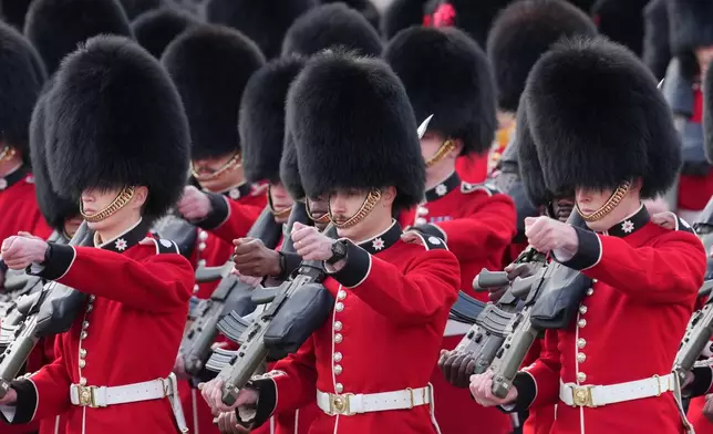 Members of the Guards march ahead of Britain's King Charles III and Queen Camilla leaving Buckingham Palace to attend the State Opening of Parliament at the Palace of Westminster in London, Wednesday, May 13, 2026.(AP Photo/Kin Cheung)