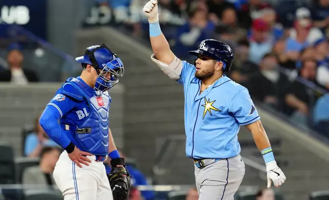 Toronto Blue Jays catcher Brandon Valenzuela, left, looks on as Tampa Bay Rays' Jonathan Aranda, right, celebrates after hitting a solo home run during fifth-inning baseball game action in Toronto, Monday, May 11, 2026. (Frank Gunn/The Canadian Press via AP)