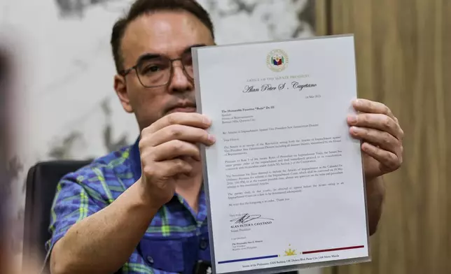 Philippine Senate President Alan Peter Cayetano holds a letter addressed to Lower House Speaker Faustino Dy III, acknowledging the Senate's receipt of the resolution containing the Articles of Impeachment against Vice President Sara Duterte, during a media briefing at the Senate in Pasay City on May 14, 2026.(AP Photo/Gerard Carreon)