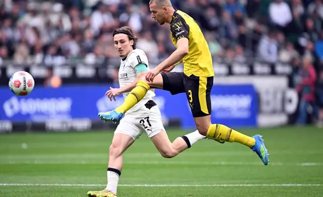 Mönchengladbach's Rocco Reitz, left, and Dortmund's Waldemar Anton fight for the ball during the German Bundesliga soccer match between Borussia Mönchengladbach and Borussia Dortmund in Mönchengladbach, Germany, Sunday, May 3, 2026. (Federico Gambarini/dpa via AP)
