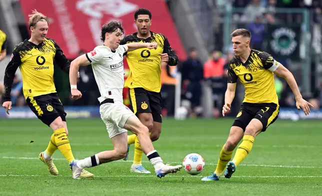 Mönchengladbach's Philipp Sander, second from left, challenges for the ball with Dortmund's Julian Brandt, left, Jobe Bellingham, second from right, and Nico Schlotterbeck during the German Bundesliga soccer match between Borussia Mönchengladbach and Borussia Dortmund in Mönchengladbach, Germany, Sunday, May 3, 2026. (Federico Gambarini/dpa via AP)