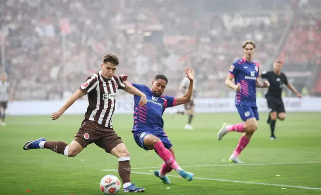 St. Pauli's Arkadiusz Pyrka, left, and Mainz's Phillipp Mwene battle for the ball during the German Bundesliga soccer match between FC St. Pauli and FSV Mainz 05 in Hamburg, Germany, Sunday, May 3, 2026. (Christian Charisius/dpa via AP)