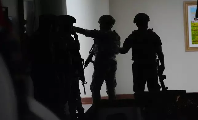 Philippine troopers exchange fire along a hallway at the Philippine Senate in Pasay, Philippines on Wednesday May 13, 2026. (AP Photo/Aaron Favila)