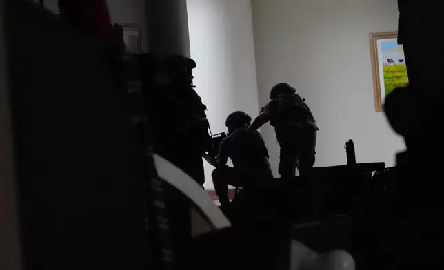 Philippine troopers exchange fire along a hallway at the Philippine Senate in Pasay, Philippines on Wednesday May 13, 2026. (AP Photo/Aaron Favila)