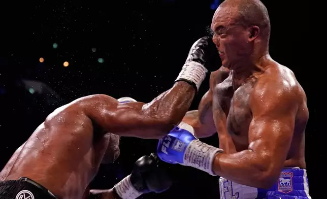Britain's Daniel Dubois, left, lands a blow on Britain's Fabio Wardley during their WBO World Heavyweight boxing title bout in Manchester, Saturday, May 9, 2026. (AP Photo/Dave Thompson)