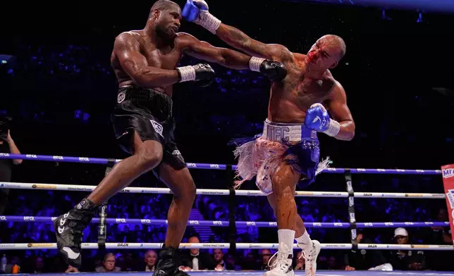 Britain's Fabio Wardley, right, swings and tries to connect with Britain's Daniel Dubois during their WBO World Heavyweight boxing title bout in Manchester, Saturday, May 9, 2026. (AP Photo/Dave Thompson)