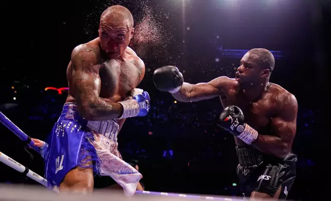 Britain's Daniel Dubois, right, lands a blow on Britain's Fabio Wardley during their WBO World Heavyweight boxing title bout in Manchester, Saturday, May 9, 2026. (AP Photo/Dave Thompson)