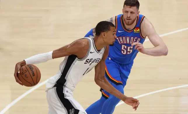 San Antonio Spurs forward Victor Wembanyama (1) controls the ball against Oklahoma City Thunder center Isaiah Hartenstein (55) during the second half of Game 2 in the Western Conference finals NBA basketball playoffs series Wednesday, May 20, 2026, in Oklahoma City. (AP Photo/Nate Billings)