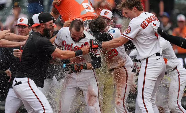 Baltimore Orioles' Colton Cowser, center, celebrates with teammates after hitting a walk off two-run home run during the 13th inning of a baseball game against the Tampa Bay Rays, Monday, May 25, 2026, in Baltimore. (AP Photo/Stephanie Scarbrough)