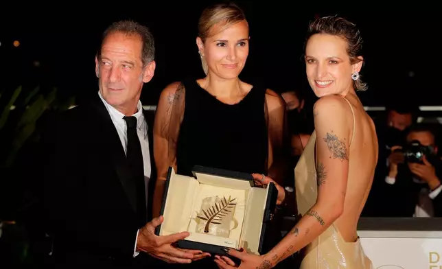 FILE - Director Julia Ducournau, center, winner of the Palme d'Or for the film "Titane" poses with Vincent Lindon, left, and Agathe Rousselle during a photo call at the 74th international film festival, Cannes, southern France, on July 17, 2021. (Photo by Vianney Le Caer/Invision/AP, File)