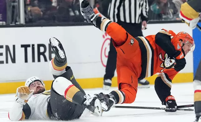 Anaheim Ducks' John Carlson (74) is tripped up by Vegas Golden Knights' Rasmus Andersson (4) during the second period of an NHL hockey game Sunday, May 10, 2026, in Anaheim, Calif. (AP Photo/Scott Strazzante)