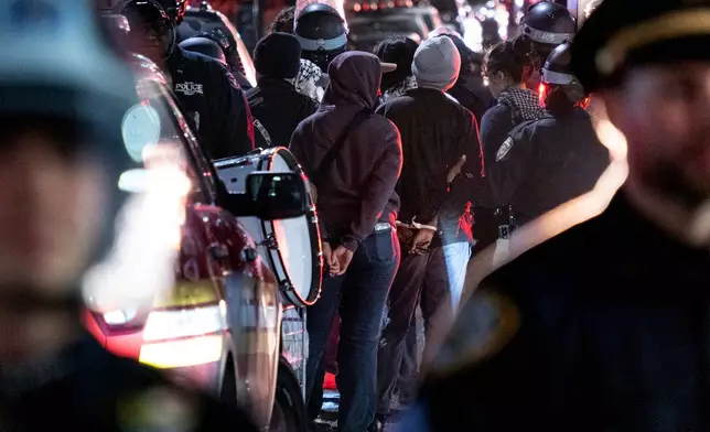 FILE - New York City police officers take people into custody near the Columbia University campus in New York Tuesday, April 30, 2024, after a building taken over by protesters earlier in the day was cleared, along with a tent encampment. (AP Photo/Craig Ruttle)