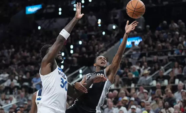 San Antonio Spurs guard De'aaron Fox (4) scores past Minnesota Timberwolves forward Julius Randle (30) during the first half of Game 5 of an NBA basketball second-round playoffs series in Minneapolis, Tuesday, May 12, 2026. (AP Photo/Eric Gay)