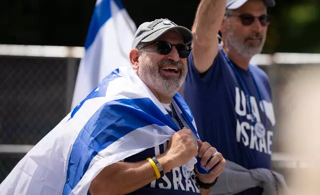 A parade participant smiles up at spectators during the Israel Day Parade, Sunday, May 31, 2026, in New York. (AP Photo/Emil T. Lippe)