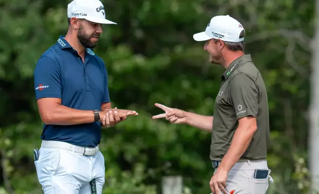 Erik Van Rooyen, left, of South Africa, and Emiliano Grillo, right, of Argentina, play 'Rock, Paper, Scissors' on the 16th green during the first round of the Canadian Open golf tournament in Caledon, Ontario, Thursday, June 11, 2026. (Frank Gunn/The Canadian Press via AP)